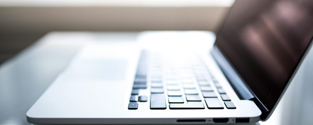 Free Elegant side view of a laptop on a glossy table with natural lighting indoors. Stock Photo