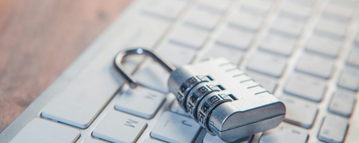 A combination lock rests on a computer keyboard.