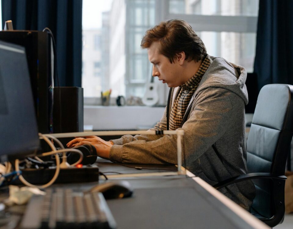 Free A concentrated professional working at a computer in a modern office setting. Stock Photo