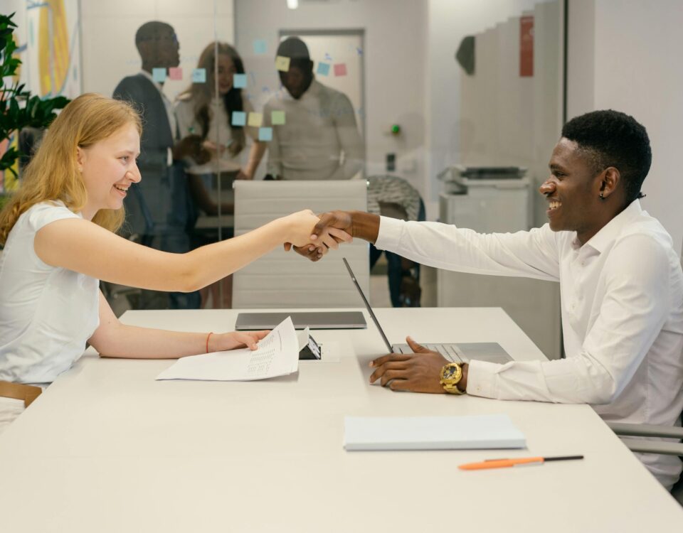 Free Business professionals completing a successful deal with a handshake in a modern office setting. Stock Photo